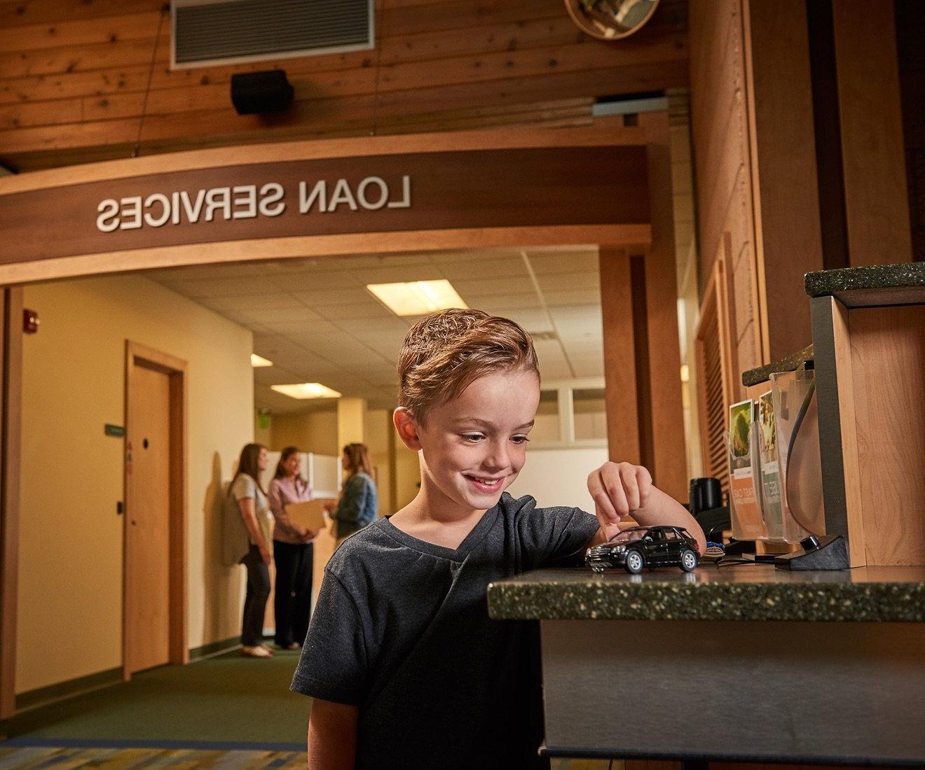 Child playing at a bank counter.